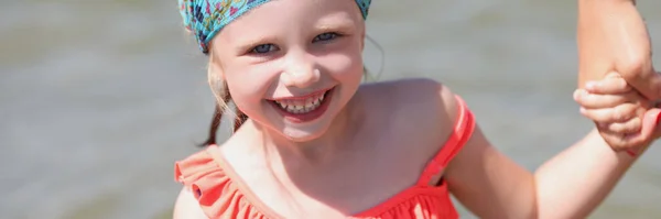 Usmívající se holčička v plavkách a šála na moři — Stock fotografie