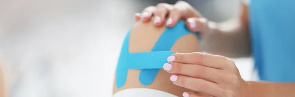 Lékař opravuje kinezio pásku na noze pacientů — Stock fotografie