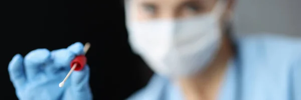 Läkare i medicinsk skyddsmask håller hyllan med provrör för provtagning av biologiskt material — Stockfoto