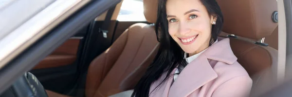 Glimlachende vrouw zitten op moderne bruine auto portret — Stockfoto