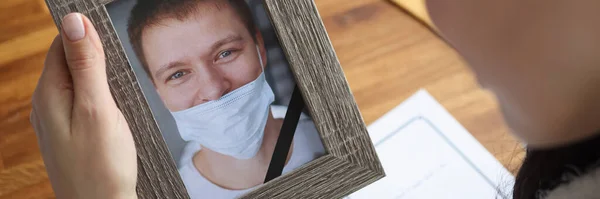 Woman crying over portrait of deceased young man closeup — Stock Photo, Image