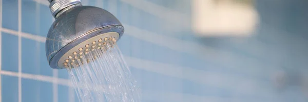 El agua fluye de la ducha de lluvia en goteos en el baño del hotel — Foto de Stock