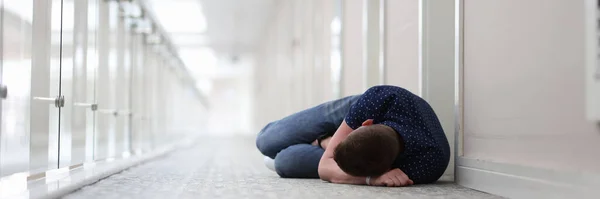 Giovane uomo dorme sotto la porta del complesso alberghiero — Foto Stock
