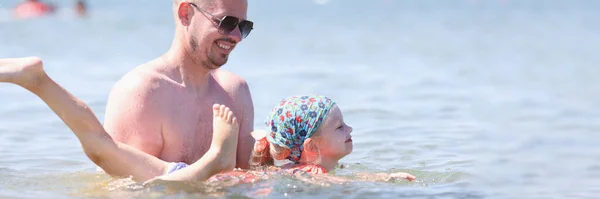 Pai ensina menina a nadar no mar — Fotografia de Stock