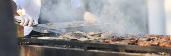 Szef kuchni przygotowuje mięso na grillu na świeżym powietrzu — Zdjęcie stockowe