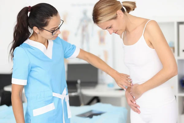 Doctor provides medical assistance to woman with abdominal pain — Stock Photo, Image