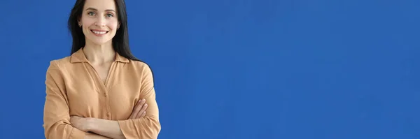 Портрет улыбающейся молодой женщины на синем фоне — стоковое фото