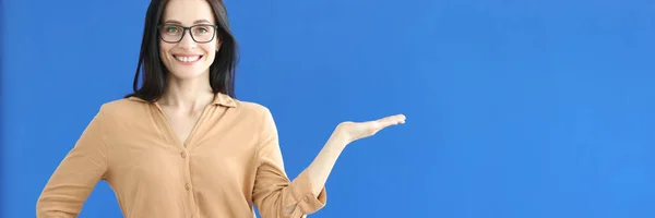 Frau mit Brille zeigt Handbewegung auf blauem Hintergrund — Stockfoto