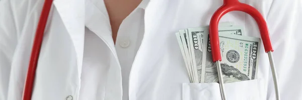 Doutor de casaco branco tem dinheiro no bolso do peito — Fotografia de Stock