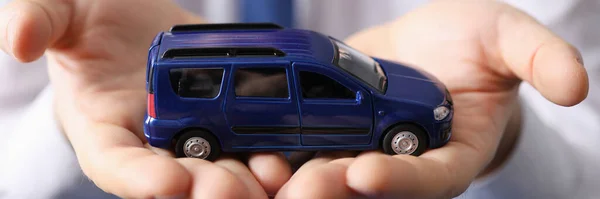 Hombre sosteniendo azul juguete coche en sus manos de cerca — Foto de Stock