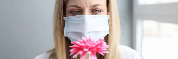 Donna in maschera medica protettiva fiuto fiore — Foto Stock