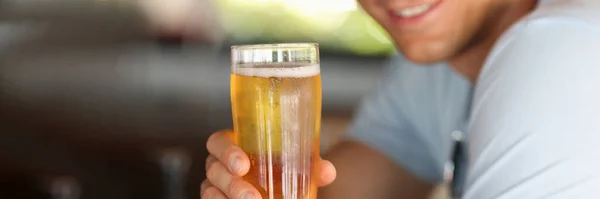 Fiatal férfi sörözik a közeli bárban. — Stock Fotó