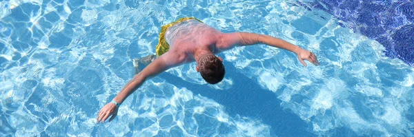 Jeune homme nageant dans la piscine vue de dessus — Photo