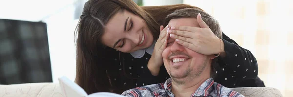 Människan läser boken hemma. Kvinnan blundar — Stockfoto