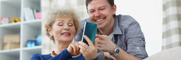 Anne ve oğul gülümsüyor ve telefon ekranına bakıyor. — Stok fotoğraf