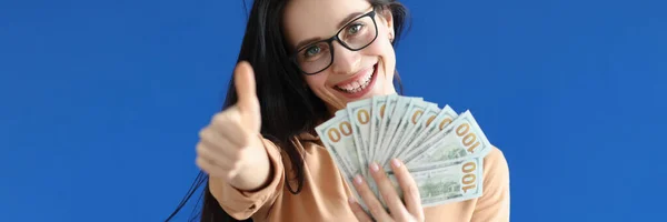 Portret van een lachende vrouw met cash dollars en duimen omhoog — Stockfoto