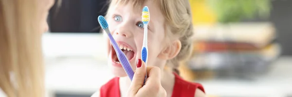 Dentista mostra escovas de dentes menina e movimentos corretos para cuidados orais — Fotografia de Stock