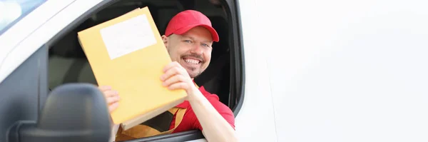 Sorrindo mensageiro masculino motorista mantém correio em suas mãos — Fotografia de Stock