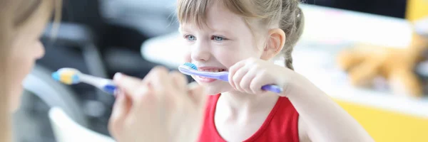 Pediatra médico ensinando menina a escovar os dentes — Fotografia de Stock