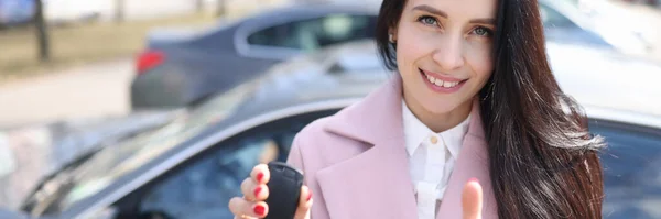 Young woman holding car keys and showing thumb up — Stock Photo, Image
