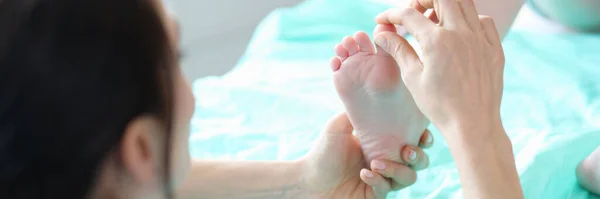 Klinikte küçük bir çocuğun ayağını muayene eden ayak doktoru. — Stok fotoğraf