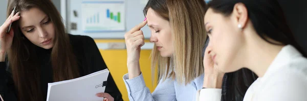 Mujeres cansadas sentadas a la mesa con documentos en las manos — Foto de Stock