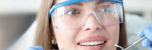 Retrato de una mujer joven con gafas de seguridad en la cita con el dentista —  Fotos de Stock