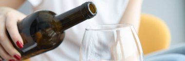 Kadın eli şarabı büyük bardağa doldurur.