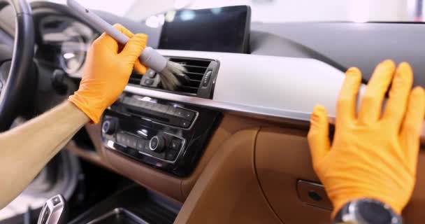 Man hand houdt grijs blozen in oranje beschermende handschoenen en reinigt ventilatiesysteem in auto 4k film — Stockvideo