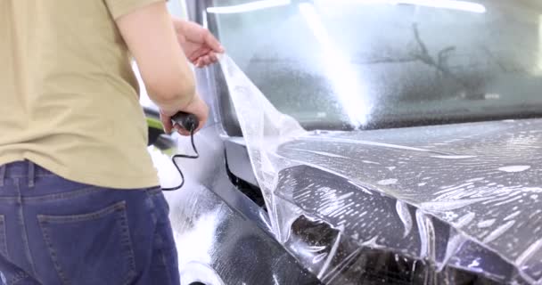 Cubrir el coche con película protectora para protegerlo de arañazos y rasguños película 4k — Vídeos de Stock