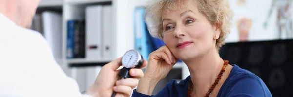 Врач измеряет артериальное давление пожилой женщины — стоковое фото