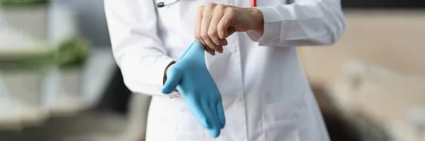 Dokter doet beschermende handschoen om zijn hand — Stockfoto