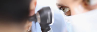 Doktor timpanik zarı otoskopla yakından inceliyor.