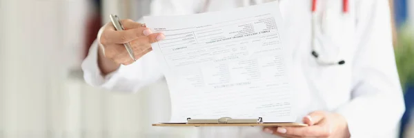 Dottore sfogliando i documenti nella storia medica del paziente in primo piano clinica — Foto Stock