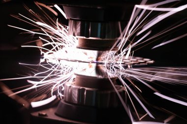 Parlak kıvılcımlarla metali kesen lazer makinesi