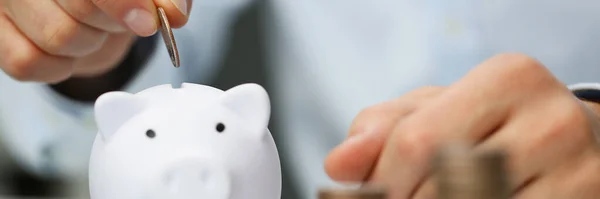 Hombre mano poner moneda en blanco alcancía primer plano — Foto de Stock