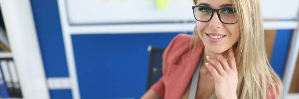 Young beautiful woman sitting at table in office