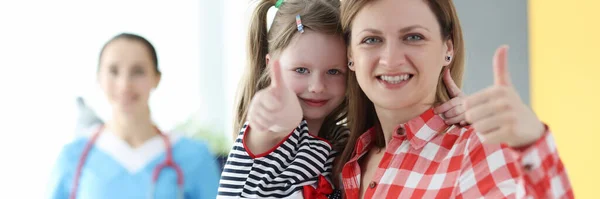 Mała dziewczynka i mama pokazuje kciuk w górę na wizytę u lekarza — Zdjęcie stockowe