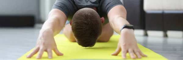 Jovem está fazendo exercícios para esticar os músculos das costas — Fotografia de Stock