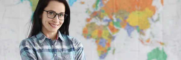 Woman teacher with glasses standing on background of world map — Stock Photo, Image