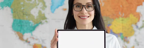 Mujer con gafas sosteniendo la tableta digital vacía en las manos sobre el fondo del mapa geográfico del mundo —  Fotos de Stock