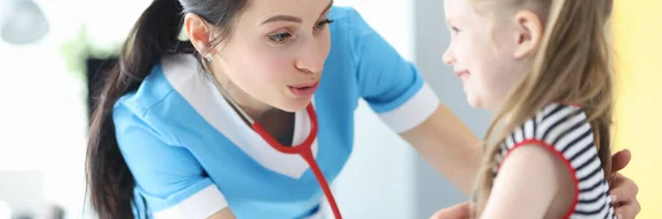 Kvinna läkare lyssnar med stetoskop liten flicka på kliniken — Stockfoto
