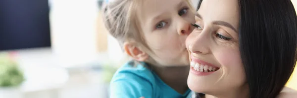 Liten flicka kysser leende mamma hemma — Stockfoto