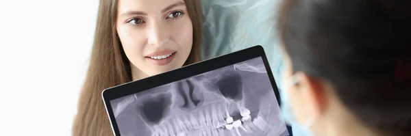 Οδοντίατρος κρατώντας ψηφιακό δισκίο με ακτινογραφία δοντιών μπροστά από τον ασθενή — Φωτογραφία Αρχείου