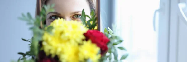 Woman holding wooden box with flowers in front of her face — Stock Photo, Image