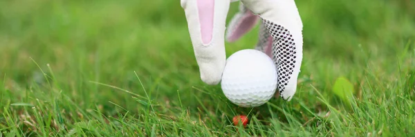 Main dans le gant de golf met la balle sur le tee-shirt de golf — Photo