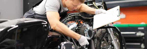 Mannelijke monteur diagnosticeert onderdelen op motorfiets bij servicecentrum — Stockfoto