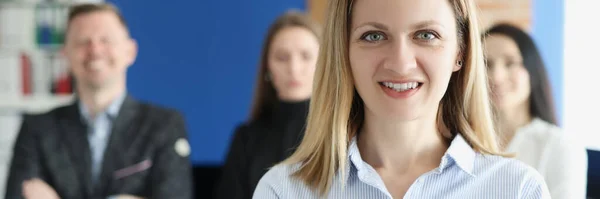 Porträtt av ung framgångsrik affärskvinna på bakgrund av kollegor — Stockfoto