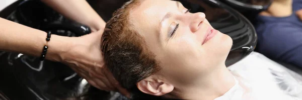 Kobieta w salonie piękności umyć włosy w zlewie — Zdjęcie stockowe