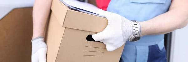 Mannelijke koerier houdt kartonnen doos met documenten — Stockfoto